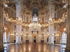 an ornate ballroom with chandeliers and windows