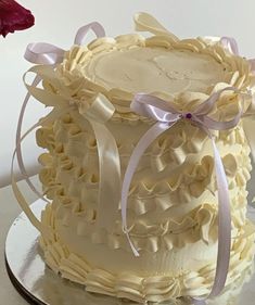 there is a wedding cake with ribbons on the top and bottom, sitting on a plate