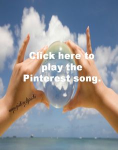 two hands are holding a crystal ball in front of the ocean with clouds and blue sky