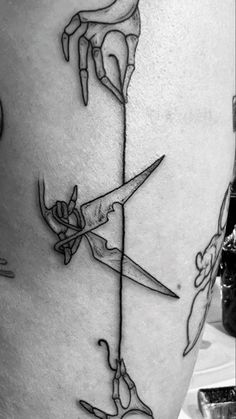 a black and white photo of a tattoo with scissors on the side of a woman's thigh