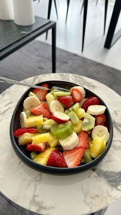 a bowl filled with fruit sitting on top of a table