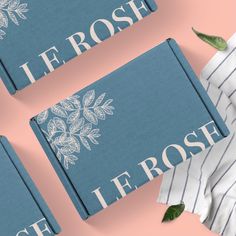 three blue books with white flowers on them and the words le rose written in french