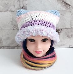 a mannequin head wearing a crocheted hat with multicolored hair