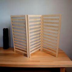 two wooden screens sitting on top of a table next to a black object in the background