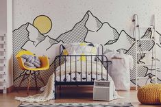 a bedroom with mountains painted on the wall next to a small bed and yellow chair