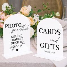 two white cards on top of a table with flowers