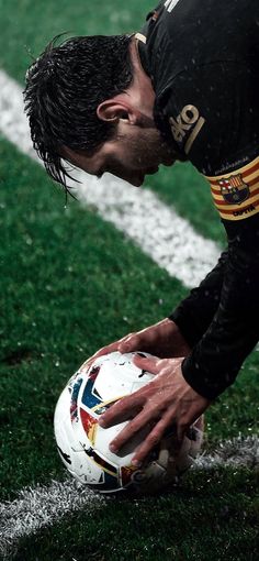 a man holding a soccer ball on top of a field