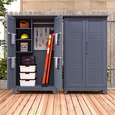 an outdoor storage shed with its doors open and tools in the bins on the deck