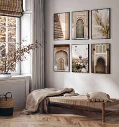 a bed sitting in front of a window next to a wall mounted art piece with pictures on it