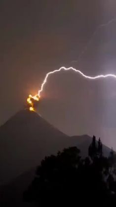 a lightning bolt is seen in the sky over a mountain