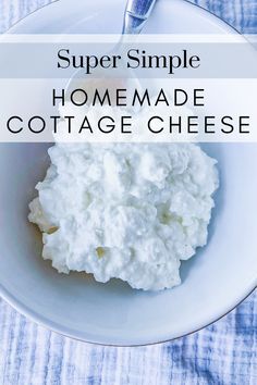 a white bowl filled with cottage cheese on top of a blue table cloth next to a fork