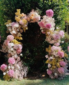 an arch made out of flowers in the grass