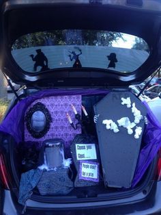 the trunk of a car is filled with halloween decorations