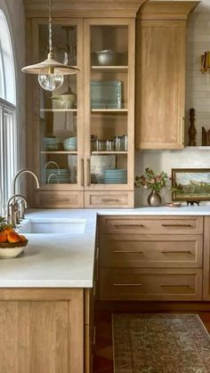 a kitchen with wooden cabinets and white counter tops