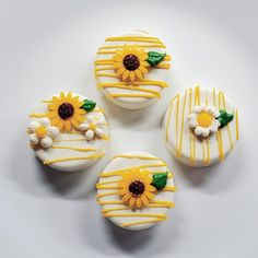 four decorated cupcakes with yellow icing and sunflowers on them are arranged in a circle