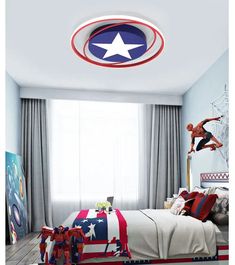 a bedroom decorated in red, white and blue with a captain america themed ceiling light