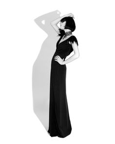 a woman in a long black dress poses for the camera