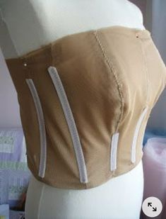 a mannequin wearing a tan top with white zippers