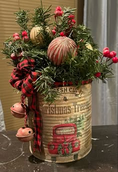 a christmas planter with red flowers and greenery in it on a black table