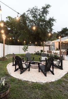 an outdoor patio with chairs and lights strung over the fire pit in the back yard