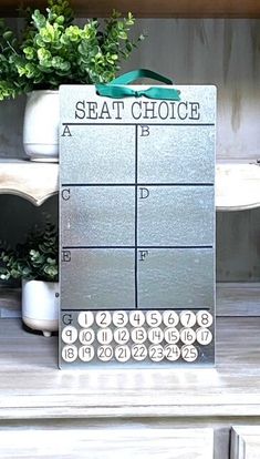 a metal sign that says seat choice on top of a wooden shelf next to potted plants