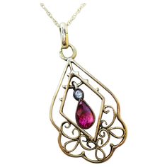 This is a stunning Edwardian Austrian pendant from 1910 in 14k yellow gold featuring a stunning red ruby center and a gorgeous old mine cut diamond accent! The pendant has a delicate, arching open design that is reminiscent of fine lace. The swirling gold arches of the pendant have a very fine milgrain detailing that is echoed in the delicate bezel setting of the center ruby and accented by the smooth bezel of the diamond! The ruby is an elegant pear shape and has a rich red and purple color wit Antique Ruby Necklace For Formal Occasions, Red Victorian Necklace For Anniversary, Red Filigree 14k Gold Jewelry, Red 14k Gold Filigree Jewelry, Victorian Ruby Pendant Jewelry, Antique Yellow Gold Teardrop Necklace, Ornate Ruby Jewelry In Yellow Gold, Antique Yellow Gold Teardrop Necklaces, Antique Teardrop Yellow Gold Necklaces