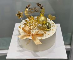 a white cake with gold decorations on top