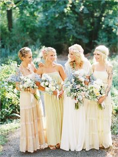 a group of women standing next to each other wearing dresses and holding bouquets in their hands