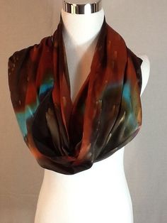 Elegant  Charmeuse Silk scarf in  Dark brown, burnt orange and turquoise. 14"x72"Product information:Designer - Mary Jane DavidsonMaterial- 100 % natural 19.5mm Charmeuse silkColor - any color choiceSize - 14"x72" slight shrinkage may occur from steamingPackage - Envelope or gift packageThis is the Porsche of silks! A muted crepe on the back side and shimmery lustrous satin on the top side. It is heavier and more substantial than plain Satin or Crepe de Chine, has a firm, soft, supple hand and a Brown Bohemian Silk Scarves, Bohemian Brown Silk Scarves, Bohemian Brown Silk Scarf, Bohemian Brown Silk Scarf For Fall, Elegant Brown Silk Scarf One Size, Burnt Orange And Turquoise, Silk Scarf Painting, Hand Painted Silk Scarf, Silk Art