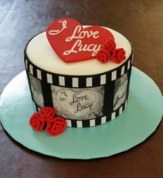 a heart shaped cake sitting on top of a blue and white plate with red roses