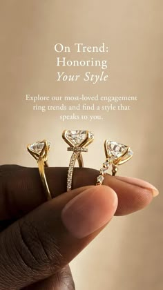 a hand holding two engagement rings with the words on trend honoring your style