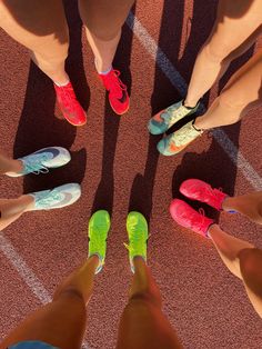 several people standing on a tennis court with their feet in the air and wearing different colored shoes