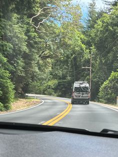 a van driving down the road with trees in the background