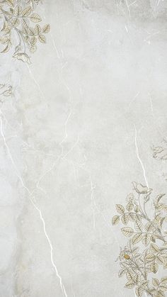 a white marble background with gold leaves and vines on it's edges is shown