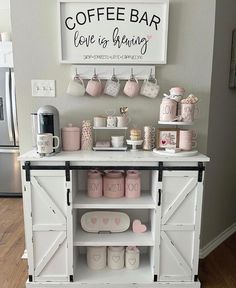 the coffee bar is decorated with pink and white mugs