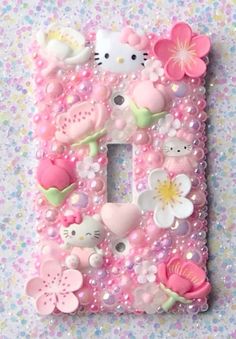 a pink and white light switch plate with hello kitty decorations on the letter e in it