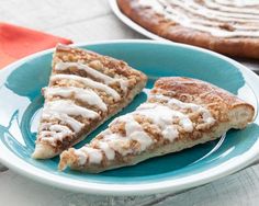 two slices of pizza on a blue plate with white icing and cinnamon crumbs