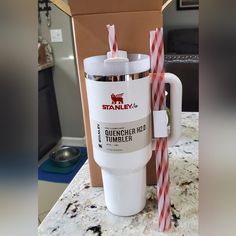 a starbucks cup with two straws in it sitting on a counter next to a cardboard box