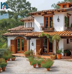 a house with potted plants in front of it and trees around the outside area