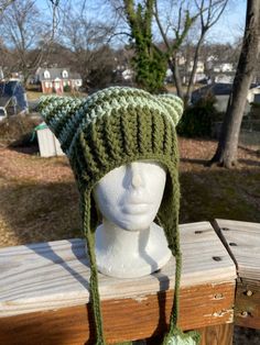 a green knitted hat on top of a white mannequin head