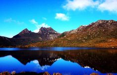 the mountains are reflected in the still water