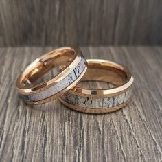 two gold wedding bands with antler wood inlays on top of each other