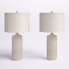 two white ceramic lamps with shades on them