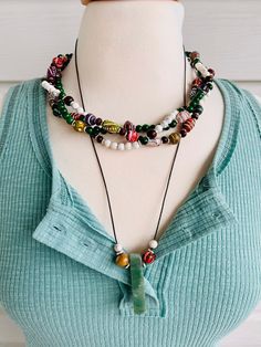 "There are lots of fantastic beads in this 3 layered braided choker necklace! Layer 1: beautiful multi colored painted wood beads with beautiful carved details.  Layer 2: rich forest green 6mm Jade beads mixed with the painted wood beads and silver details. Porcelain beads have been mixed in for a nice added element. Layer 3: cloudy white  6mm stone beads with chocolate wood beads and green Jade beads. This choker measures about 17\" but will have a 2\" extension so that you can elongate if needed. Complimented with a Green Adventurine Stone Pendant Necklace. Chocolate brown cord, Green Adventurine Stone Pendant Necklace. Stone, Wood and Porcelain adorn the pendant on either side.  This cord necklace will have a 26\" head hole and you can adjust the knot. It will slide over your head. Gree Painted Wood Beads, Hammered Necklace, Pave Jewelry, Porcelain Beads, Key Lock, Cz Pendant, Stone Pendant Necklace, Jade Beads, Green Jade