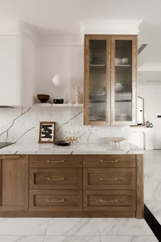 a kitchen with marble counter tops and wooden cabinets