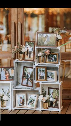 an arrangement of pictures and flowers are on display in a wooden box with multiple frames