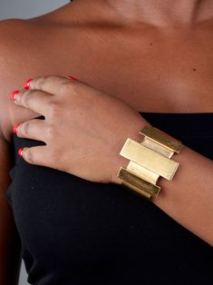 Prepare for endless compliments with this eye-catching bracelet. The Cala Bar Statement Cuff is a striking art-deco-inspired piece featuring a brushed matte 24k gold-plated finish over recycled brass. Its sleek rectangular columns and craftsmanship make it the perfect accessory to elevate your look. Dimensions: Center Accent: 0.59in x 1.77in (15mm x 45mm) Side Accents: 0.39in x 1.37in (10mm x 35mm) Maximum height: 1.7in (45mm) Essence Collection, Vacation Looks, Bold Art, Central African, Elevate Your Look, Art Deco Inspired, Wallet Bag, Pop Up Shop, Egift Card