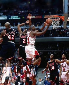 the basketball player is jumping up to dunk the ball in front of the other players