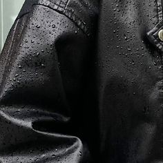 a man in black leather jacket with rain drops on his coat