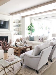 a living room filled with furniture and a flat screen tv mounted on the wall above a fireplace